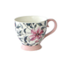 Floral-patterned mug with pink handle on a white background