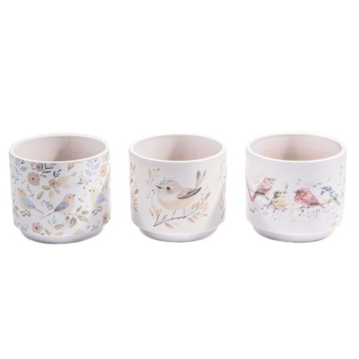 Three ceramic cups with floral and bird designs on a white background