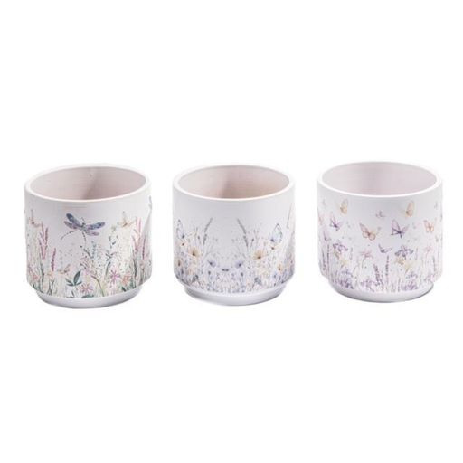 Three ceramic cups with floral and butterfly designs on a white background