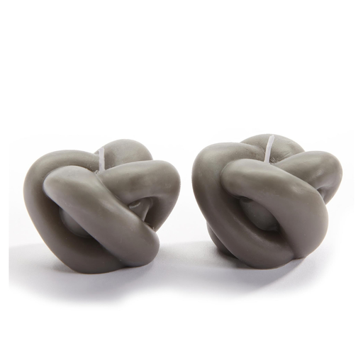 Two knot-shaped candles on a white background