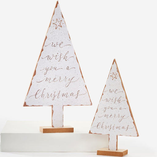 Two distressed white wooden Christmas tree signs with copper-toned script reading 'we wish you a merry christmas' and small star details, displayed on a white pedestal against a white background.