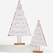 Two distressed white wooden Christmas tree signs with copper-toned script reading 'we wish you a merry christmas' and small star details, displayed on a white pedestal against a white background.