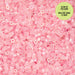 Pink glow-in-the-dark beads with a green label on a pink background