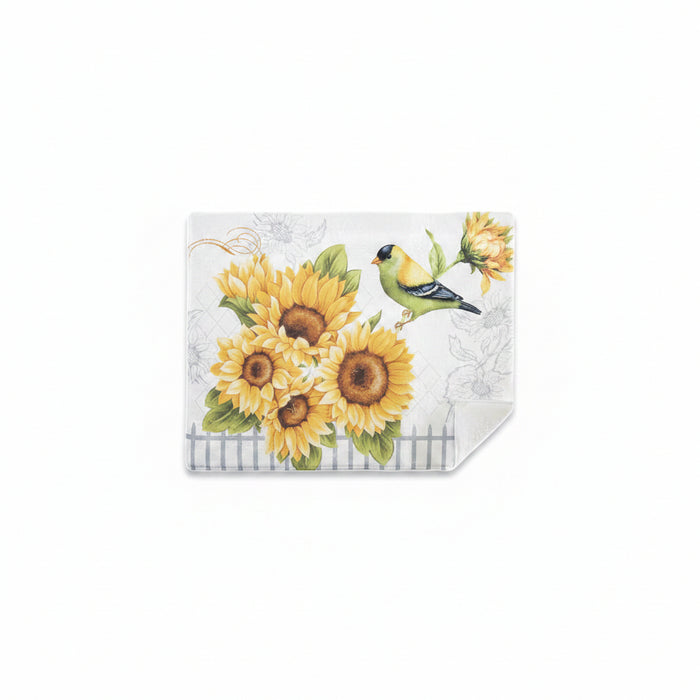 A square decorative wall hanging or panel with a printed design of yellow sunflowers, green leaves, and a green-and-yellow bird on a light background. The bottom right corner is folded over, showing a textured reverse side, against a plain white background.