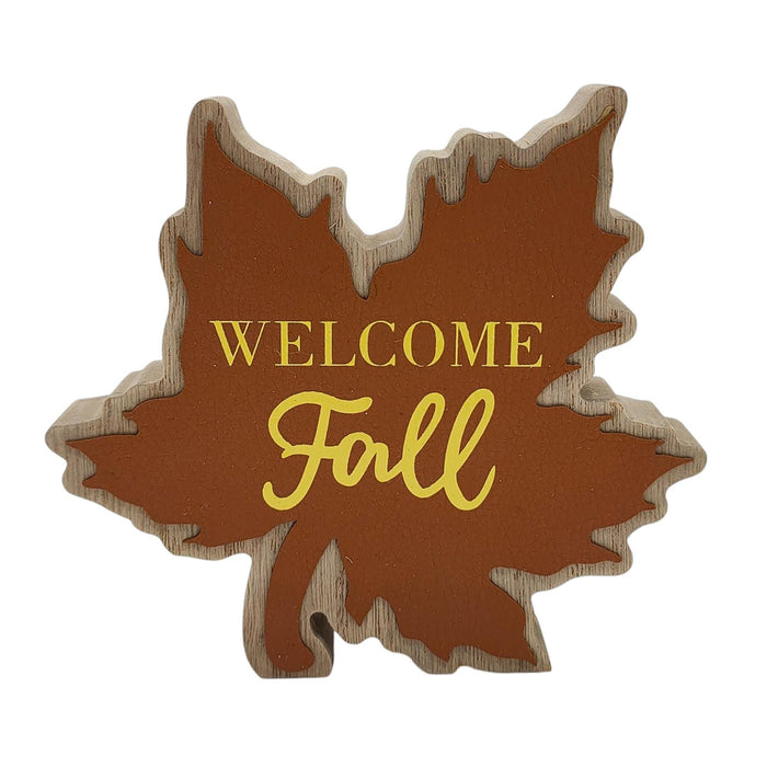A decorative autumn leaf-shaped sign with a brown center, natural wood edges, and the words 'WELCOME Fall' in gold lettering, shown on a plain white background.