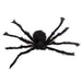 A black fuzzy spider decoration or toy shown against a plain white background.