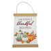 A hanging fabric wall sign with a light wood top and bottom border, featuring the phrase 'Grateful thankful blessed' above an autumn illustration of pumpkins, sunflowers, and leaves. A thin rope hanger is attached at the top.