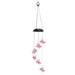 Solar-powered wind chime with pink butterfly designs on a white background