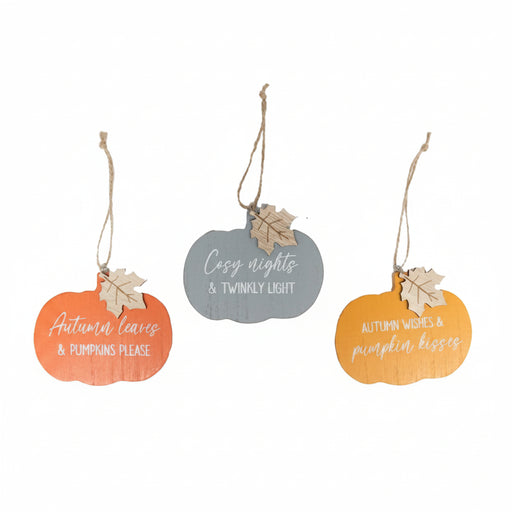 Three autumn-themed wooden hanging ornaments shaped like pumpkins, each with a natural jute hanging string and a small leaf accent. The left ornament is orange and reads 'Autumn leaves & pumpkins please.