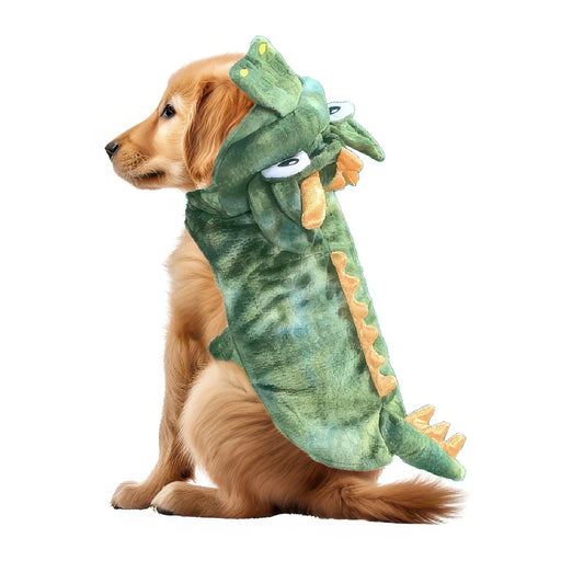 A golden retriever dog wearing a plush green dinosaur costume hood with orange spikes and white cartoon eyes, photographed on a plain white background.