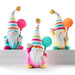 Three colorful gnome figurines with striped hats and balloons on a white background