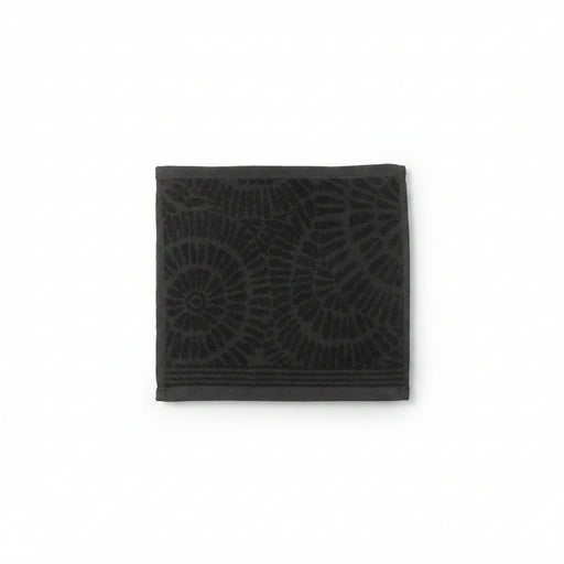A dark charcoal gray square towel featuring a tonal embossed spiral and leaf-like pattern, shown flat against a plain white background.