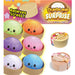 Dumpling Surprise Bouleuses toy set featuring six colorful, smiling steamed dumplings in tan bamboo-style holders, with two sealed round packages shown on the right. The packaging includes a colorful header card reading 'Dumpling Surprise' and 'Relieves Stress!'.