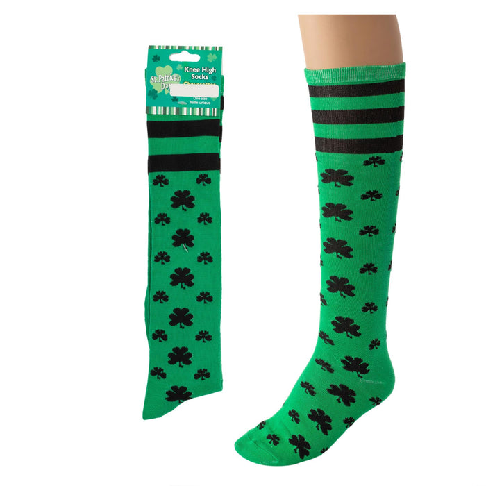 Green knee-high socks with black shamrock pattern and packaging on a white background