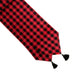 A red and black buffalo check plaid table runner with black tassels on a white background.