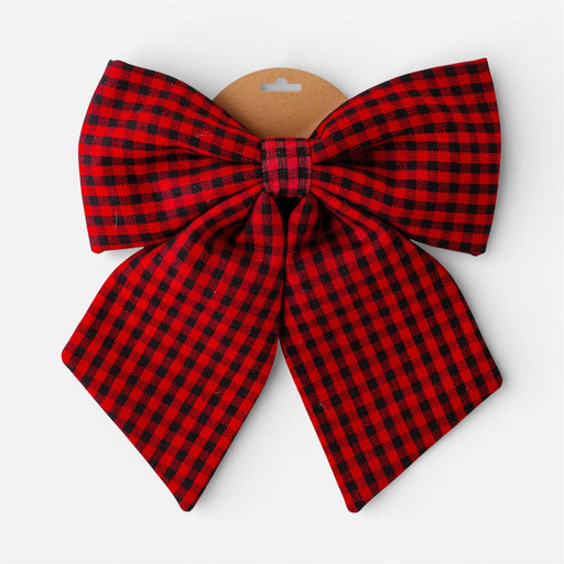 A large fabric bow in a red and black buffalo plaid pattern, attached to a brown cardboard hanger against a light gray background.