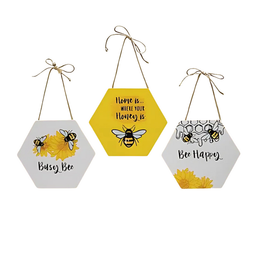 Assorted bee-themed hexagon signs with sayings — Busy Bee, Bee Happy, and Home is… Where Your Honey Is — featuring yellow, white, and honeycomb designs with jute hangers.