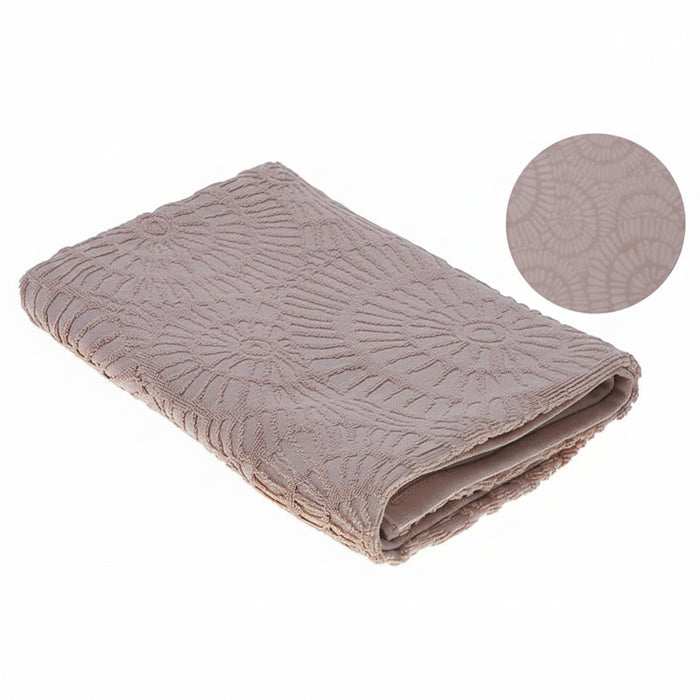 A folded dusty rose pink textured blanket with a raised circular floral pattern, shown on a white background with a circular fabric detail inset in the top right.