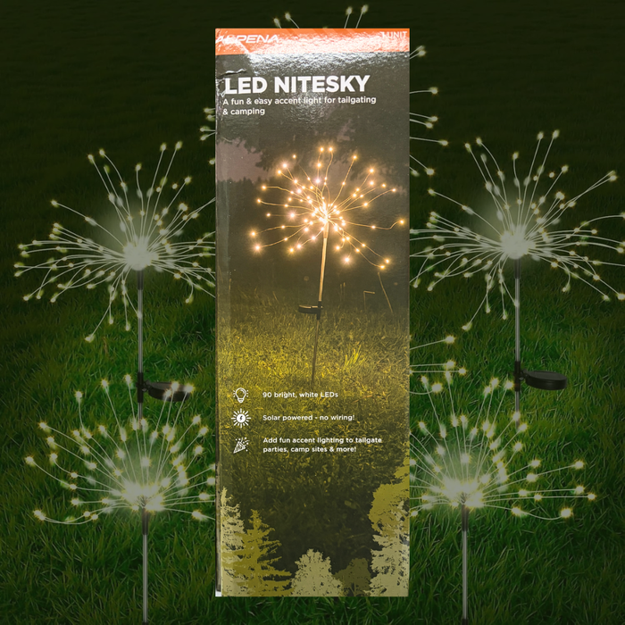 A tall retail package for Nitesky LED niteski sparkler stakes stands upright on grass, with several illuminated sparkler lights arranged around it against a dark grassy background.