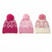 Three pink knit pom-pom beanies with bow patterns, displayed side-by-side on a white background.