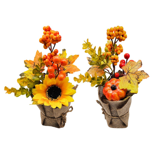 Two autumn-themed artificial floral arrangements in burlap-wrapped pots, featuring a yellow sunflower, orange berries, green and yellow leaves, and a small orange pumpkin, shown on a white background.