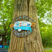 Decorative sign with 'Happy Campers' and a camper design on a tree trunk.