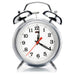 Silver alarm clock with a white face on a white background