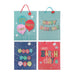Four colorful birthday gift bags arranged in a 2x2 grid on a white background. The top-left bag is light blue with balloons and the text 'IT'S PARTY TIME!'; the top-right bag is light blue with 'HAPPY BIRTHDAY' in pastel letters; the bottom-left bag is dark blue with 'JUST FOR YOU' in round letters; the bottom-right bag is pink with 'HAPPY Birthday !!!' in multicolor letters.