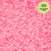 Pink glow-in-the-dark beads on a pink background with a green label.