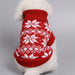A small white dog wearing a red knit sweater with a white snowflake and diamond pattern, photographed against a plain light gray background.