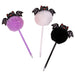 Three Halloween-themed decorative pens with fluffy pom-poms and bat details, shown on a plain white background. One pen has a purple pom-pom and purple body, one has a white pom-pom and clear body, and one has a black pom-pom and black body.