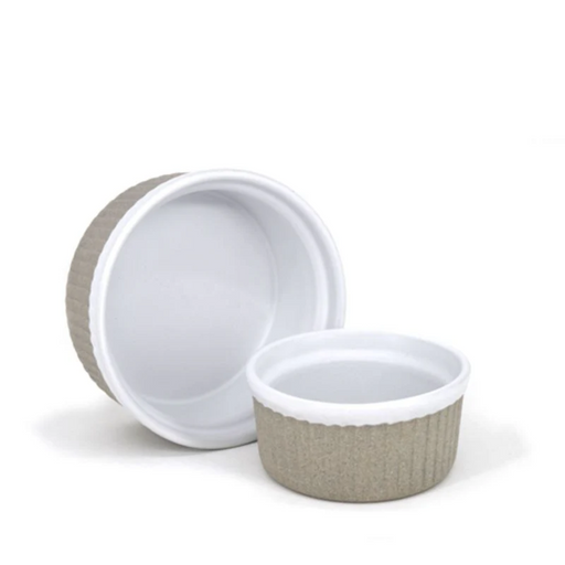 Two ceramic ramekins with textured gray exterior and white interior on a white background