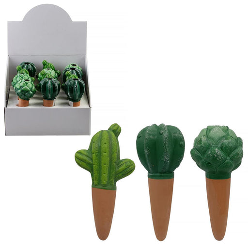 Green cactus-shaped items on terracotta pots with a display box in the background.