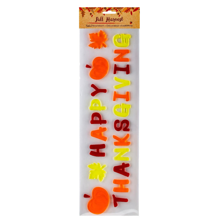 A packaged 'Fall Harvest' 'Happy Thanksgiving' foam banner decoration set, featuring orange pumpkins, yellow and red autumn leaves, and colorful lettering on a white background.