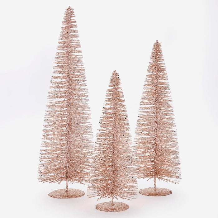Three rose gold metallic bottle brush Christmas trees in varying heights, standing on round bases against a white background.