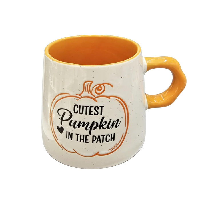 A ceramic mug with a speckled off-white exterior, a bright orange interior and handle, and a printed pumpkin graphic with the text 'Cutest Pumpkin in the Patch'.