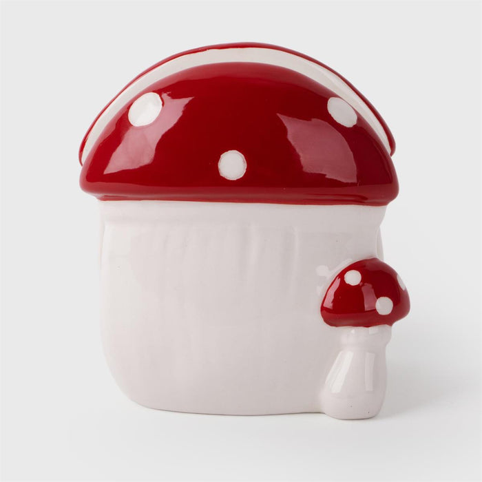 Ceramic mushroom-shaped container with a red cap and white spots on a light gray background