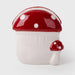 Ceramic mushroom-shaped container with a red cap and white spots on a light gray background