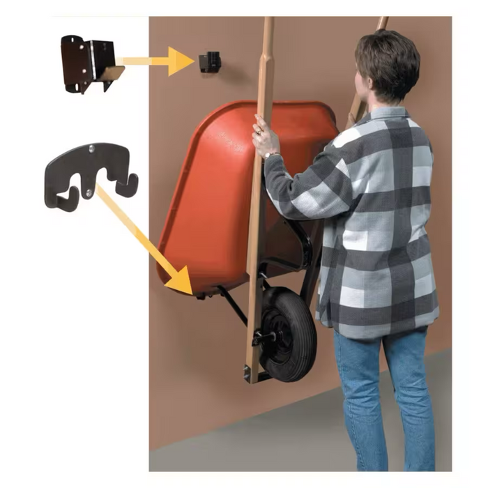 Person using a tool to open a door with a red wheelbarrow attached, against a plain background.
