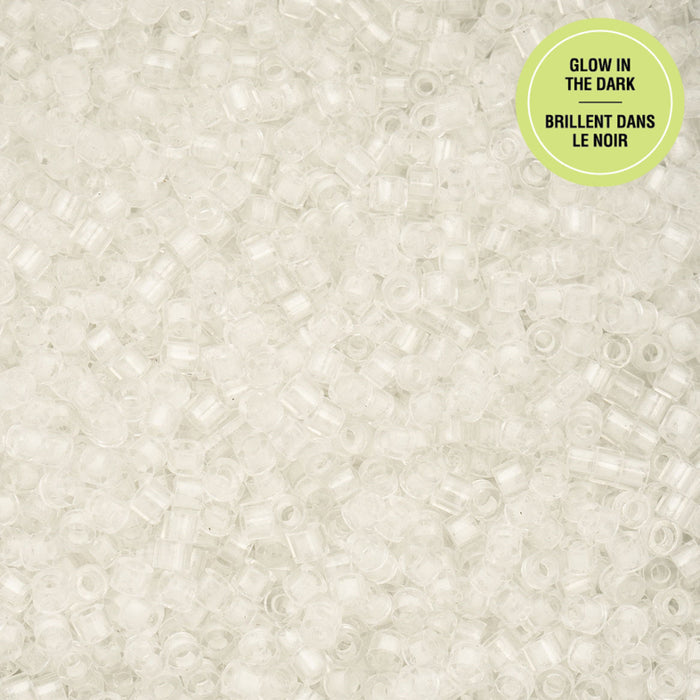 Close-up of small beads with a 'Glow in the Dark' label on a light gray background