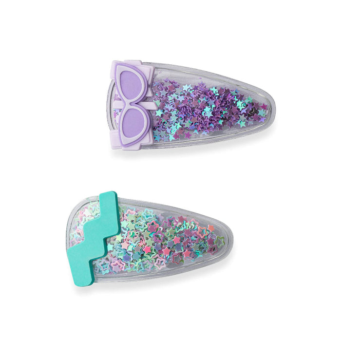 Two colorful children’s hair clips filled with glittery star-shaped confetti. The top clip has purple stars with a lavender sunglasses decoration on one end, and the bottom clip has multicolored pastel stars with a teal zig-zag design on one end.