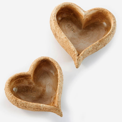 Two heart-shaped ceramic bowls on a white background