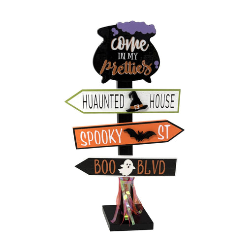 Halloween decorative signpost with four directional arrow boards reading 'Come in my pretties', 'Huaunted house', 'Spooky st', and 'Boo blvd', plus a cauldron, bat, ghost, and striped witch hat accents, on a white background.