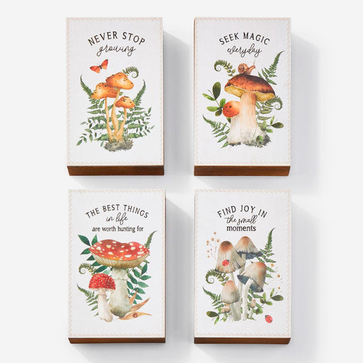 Four wooden blocks with mushroom illustrations and motivational quotes on a white background