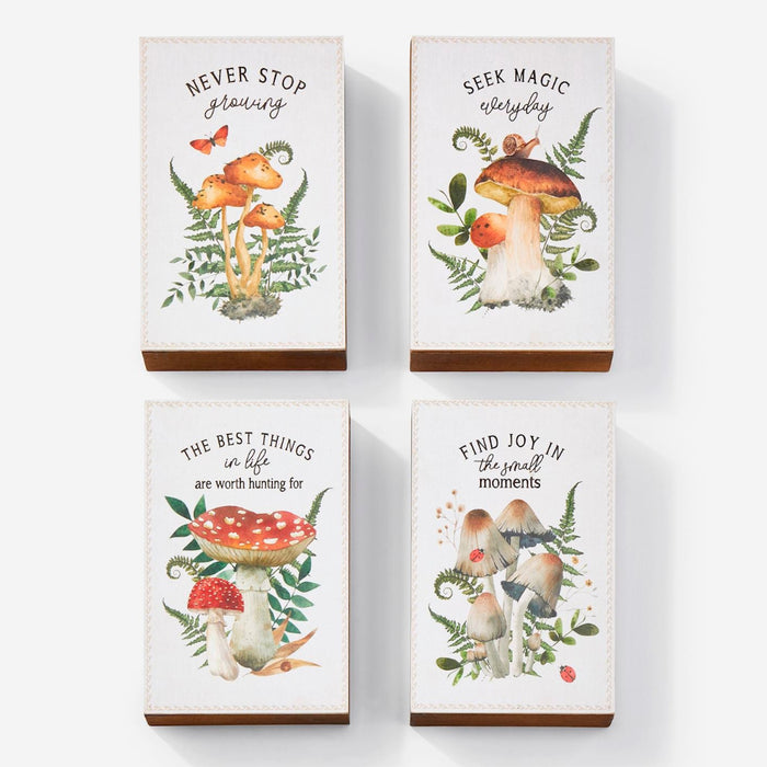 Four wooden blocks with mushroom illustrations and motivational quotes on a white background