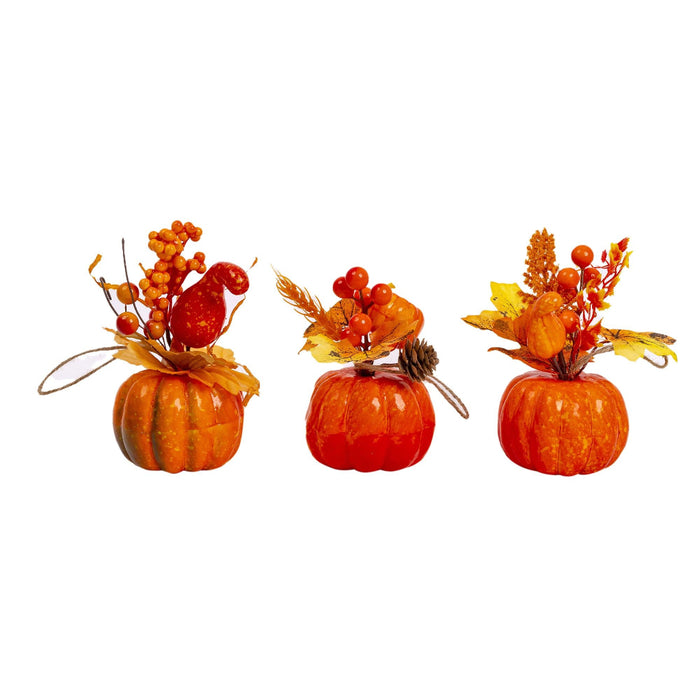 Three small decorative pumpkins arranged side by side on a plain white background, each topped with autumn floral arrangements in orange, red, yellow, and brown.