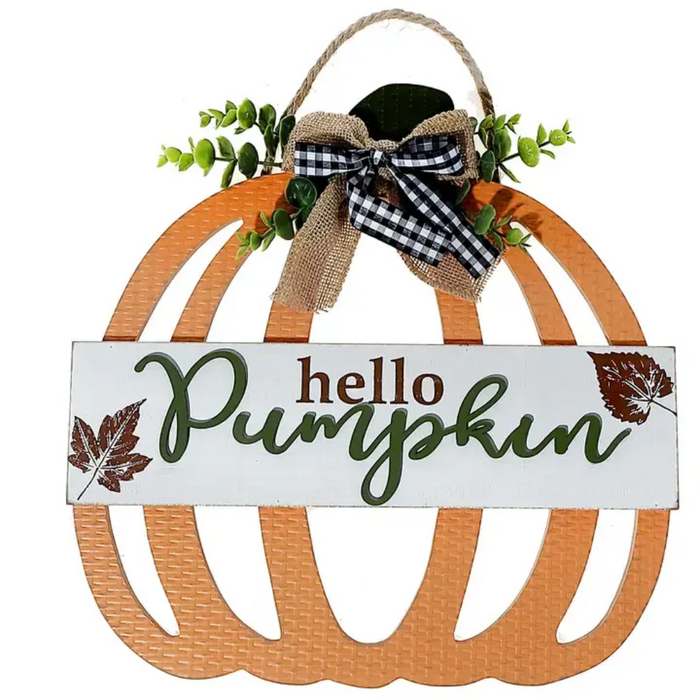 A decorative autumn hanging sign shaped like a pumpkin, with a white front panel reading “hello Pumpkin” in brown and green lettering, plus leaf illustrations. The sign has an orange scalloped pumpkin frame, a rope hanger, a burlap ribbon bow, and greenery accents on a white background.
