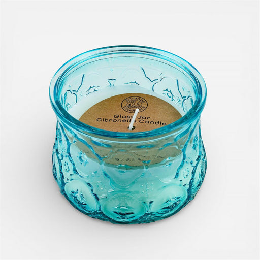 Blue glass candle with a visible brand label on a white background