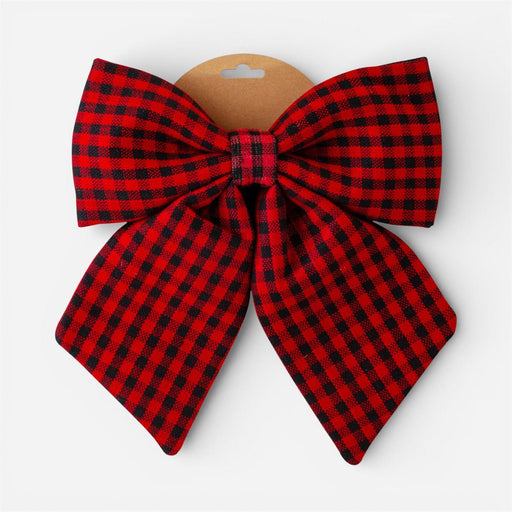 A large red and black buffalo plaid bow with a brown cardboard hanger, shown against a plain light gray background.
