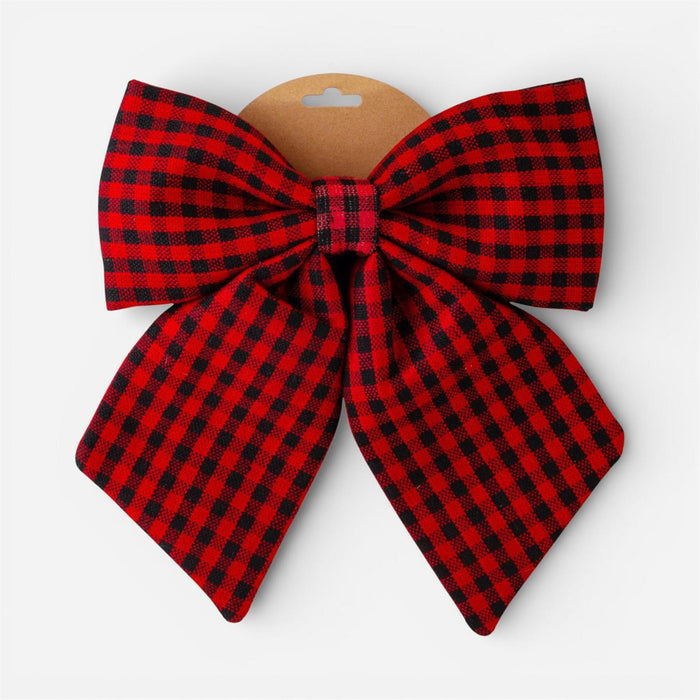 A large red and black buffalo plaid bow with a brown cardboard hanger, shown against a plain light gray background.